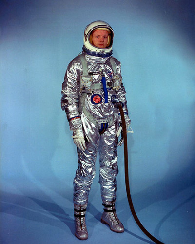 Vemos un hombre en traje de astronauta plateado con cierres un casco con amplio visor guantes 